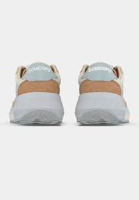 Saucony sneakers with a beige upper, brown suede accents, and a light blue heel tab. Thick gray sole with textured tread pattern.