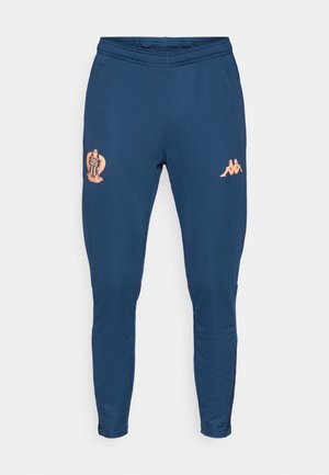 Pantalones deportivos azules con cintura elástica, logo de OGC Nice en el muslo izquierdo y logo de Kappa en el muslo derecho, pantalones ajustados con cremalleras en los tobillos.