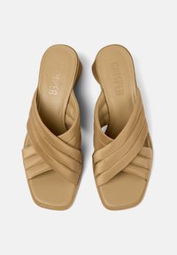 Infradito beige con cinturini incrociati, rifiniti in pelle liscia e design a punta quadrata. Presentano una soletta imbottita e il logo del brand impresso.