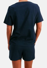 Navyblauw katoenen T-shirt met korte mouwen en bijpassende korte broek. Eenvoudig ontwerp met een ontspannen pasvorm, gladde textuur en zonder zichtbare patronen of hardware.