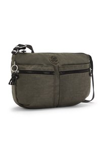 Olive green nylon handbag with two zippered front pockets, a round logo, and a detachable keychain charm. Features an adjustable shoulder strap.