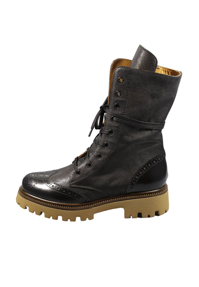 Stivaletto alla caviglia in pelle nera con design brogue, punta arrotondata, suola in gomma e battistrada contrastante color cuoio. Presenta una chiusura con lacci nella parte anteriore e un colletto imbottito.