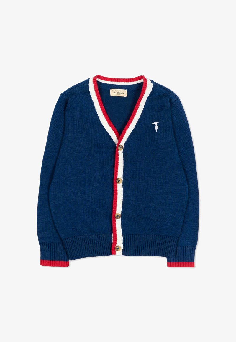 Cardigan bleu marine avec bordure rouge et blanche le long du col en V et de la ligne de boutons, boutons en bois, et un petit logo oiseau blanc sur la poitrine.
