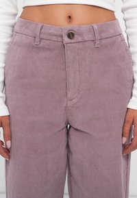 Lila corduroy broek met een hoge taille, voorzien van verticale ribbels, een knoopsluiting en zijzakken. Textielachtig stof met een zachte afwerking.