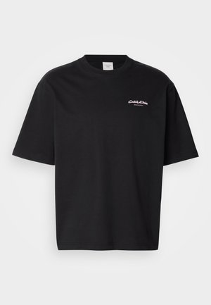 Fekete pamut póló laza szabással, rövid ujjakkal és fehér Calvin Klein logóval a mellkason. Simma textúra, kerek nyakkivágás.