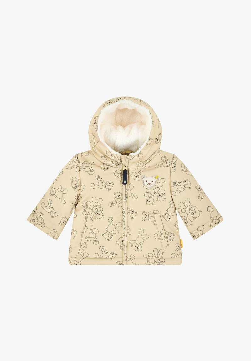 Doudoune beige avec un motif ours en peluche, fermeture éclair et capuche doublée en peluche. Elle dispose de deux poches avant et de poignets ajustables.