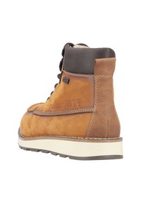 Bruine suède enkellaars met donkerleren afwerking, vetersluiting aan de voorkant, versterkte achterkant, rubberen zool en ingebosseerd logo aan de zijkant.