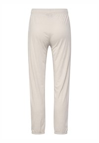 Light beige jogger pants made of soft fabric, featuring an elastic waistband and cuffs, with a loose fit and no visible patterns.