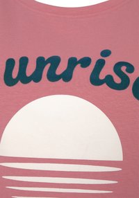Camiseta de algodón en rosa suave con texto azul oscuro que dice "unrise" sobre un gran círculo blanco que representa el sol y líneas horizontales debajo.