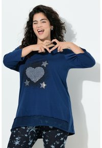 Maglietta a manica lunga blu navy con design di cuore e stella argentati e strass; abbinata a leggings blu scuro con motivo a stelle.