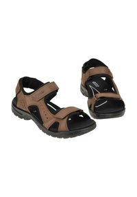 Brown leather sandals with adjustable straps, open-toe design, and black rubber soles featuring textured accents and ventilation holes.