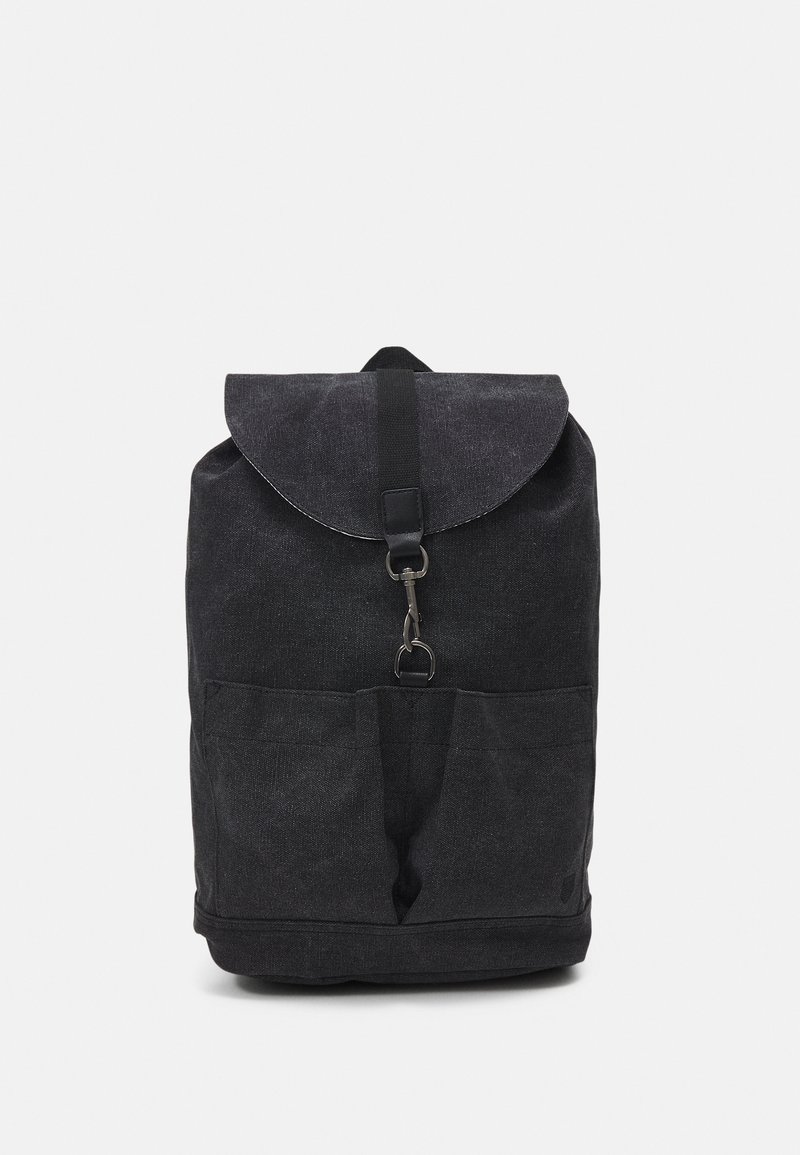 Sac à dos en tissu noir avec rabat avant sécurisé par une fermeture métallique et deux poches avant, présenté sur un fond blanc uni.