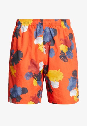Shorts orange vif avec taille élastique et motifs de feuilles tropicales multicolores en bleu, jaune, blanc, noir et rouge.