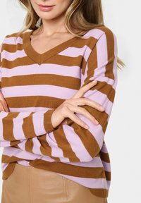 Maglione a righe marroni e rosa, con scollo a V, maniche lunghe e polsini a costine, caratterizzato da una consistenza morbida e una vestibilità rilassata.