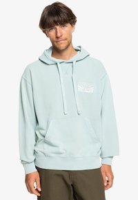 Light blue hoodie with a front pocket and drawstrings. Features a white graphic print on the chest. Made of soft, textured fabric.