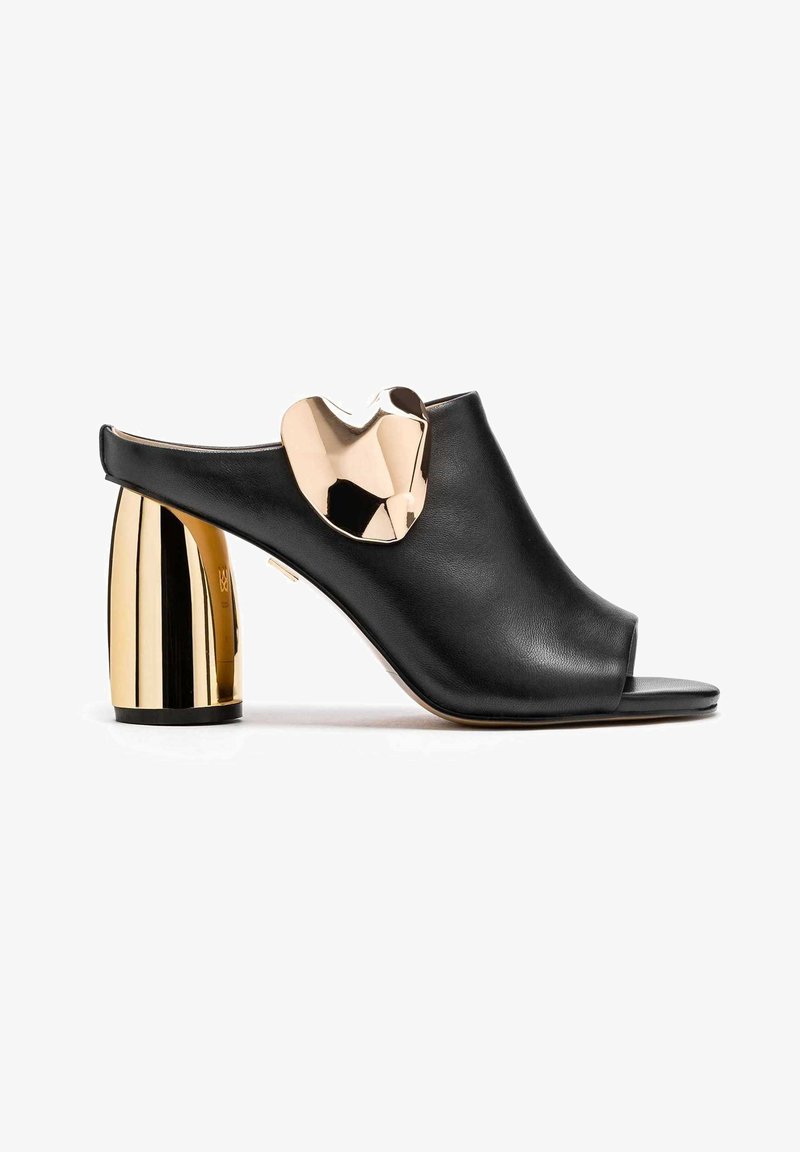 Mule en cuir noir à bout ouvert avec un talon cylindrique doré brillant et épais et un grand détail en forme de cœur doré réfléchissant sur le dessus.