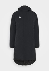 Long manteau noir matelassé à capuche Nike avec fermeture éclair frontale et logo "Nike F.C." sur la poitrine.