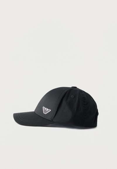Μαύρο καπέλο μπέιζμπολ με καμπυλωτή γείσο και μικρό λευκό στυλιζαρισμένο λογότυπο στο μπροστινό πάνελ, εμφανίζεται σε απλό ανοιχτό φόντο.