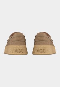 Ζευγάρι καφέ μοκασίνια σουέντ με χοντρές λαστιχένιες σόλες, με ανάγλυφο το «AGL» στη φτέρνα, εμφανιζόμενα από πίσω σε λευκό φόντο.
