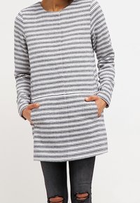 Tunique a maniche lunghe a righe realizzata in un tessuto morbido, con righe orizzontali grigie e bianche, scollatura rotonda e tasche frontali.