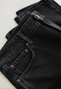 Černé džíny z denimu se slim fit střihem. Obsahují pět kapes, měděné komponenty a kontrastní prošívání. Hladká textura s mírným leskem.