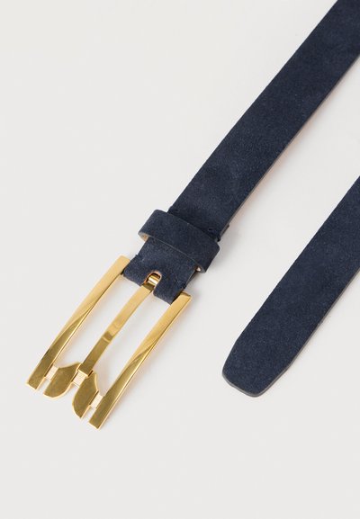 Ζώνη από σουέντ σκούρου μπλε χρώματος με μοναδικό γυαλιστερό χρυσό αγκράφα με τριπλό καρφί, τοποθετημένη επίπεδα σε λευκή επιφάνεια.