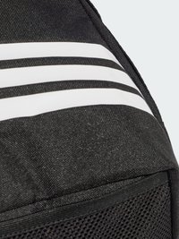 Mochila negra con rayas blancas, tela texturizada, detalles de malla y un bolsillo con cremallera. Diseño compacto con costuras resistentes.