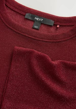 Burgundy bordázott pulóver texturált felülettel, kerek nyakkal és egy kis elülső zsebből. A címke szerint "NEXT", török gyártású.