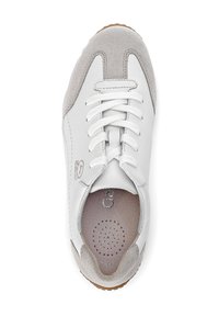 White sneaker with grey suede accents. Features round perforations on the insole, flat white laces, and a rubber sole for traction.