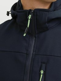 Marineblauwe jassen met een rits aan de voorkant, een hoge kraag en groene trekkoorden. Kenmerkt zich door gladde stof en een getailleerd ontwerp.