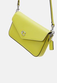 Borsa a tracolla gialla in pelle con superficie texture, hardware in argento, patta ripiegabile e bordi in contrasto neri. Presenta un piccolo etichetta.