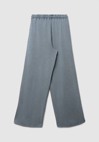 Pantalons de survêtement gris à jambes larges, avec une taille élastique et une texture lisse. Caractérisés par une coupe décontractée avec des côtés droits et un ourlet propre.