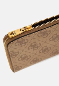 Brown zippered wallet with a textured surface, featuring a repeating logo pattern. Gold hardware and stitching accentuate the design.