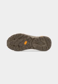 Καφέ, ανθεκτική λαστιχένια σόλα με βαθιά, πολυκατευθυντικά αυλάκια και πορτοκαλί λογότυπο Vibram κοντά στο κέντρο και τη φτέρνα.