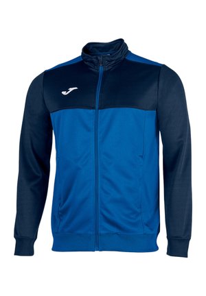 Blå og marineblå sportjakke med lynlås, lange ærmer, høj krave, to forlommer og hvidt logo på venstre bryst.