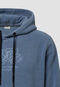 Blauwe fleece hoodie met een gestructureerde oppervlakte, voorop bedrukt met een logo en zwarte trekkoorden. Ontworpen met een standaardcapuchon en een buidelzak.