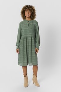 Grön klänning med långa ärmar, volangkrage, knappstängning fram och texturerade ränder. Kjolen har en lätt utsvängd form med en rynkad midja.