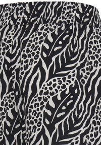 Czarnobiały wzorzysty materiał z motywami zwierzęcymi i liściastymi, z elastycznym pasem.