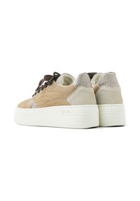 Baskets en suède beige avec une semelle plateforme, présentant un panneau arrière texturé, des lacets marron et un logo sur le côté.