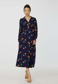Robe florale navy avec un décolleté en V, des manches longues, une taille ceinturée et un motif floral avec des accents orange et jaune. Design mi-long.