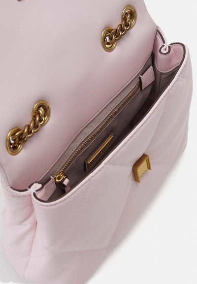 Sac à main en cuir rose pâle avec des anses en chaîne dorée, fermoir doré et poche intérieure zippée visible à l'intérieur du rabat ouvert.