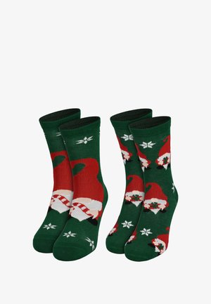 Grüne Socken mit einem wiederholten Muster aus Weihnachtsmützen und Schneeflocken in Rot, Weiß und Schwarz. Gerippte Bündchen oben.