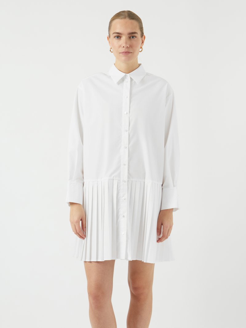 Robe chemise blanche avec un col et des boutons sur le devant. Dotée d'une section de jupe plissée et de manches longues. Fabriquée dans un tissu lisse.