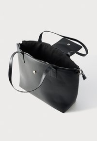 Μαύρη δερμάτινη τσάντα tote με δύο μακριά χερούλια, κλείσιμο με φερμουάρ και τσέπη με κουμπί στην εσωτερική πλευρά. Λεία υφή και μινιμαλιστικός σχεδιασμός.
