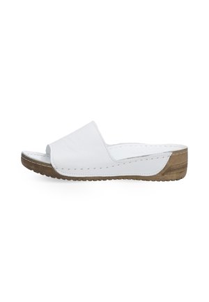 Witte leren slipper met een vlakke houten zool, open te ontwerp en contrasterende stiksels langs de rand. Zachte textuur.