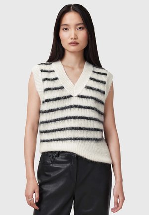 Maglione senza maniche a strisce bianche e nere con scollo a V profondo, texture morbida e vestibilità rilassata, abbinato a pantaloni in pelle nera.