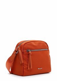 Borsa a tracolla arancione in nylon con tasca anteriore con zip, frange decorative e hardware argentato. Forma compatta e quadrata con tracolla regolabile.
