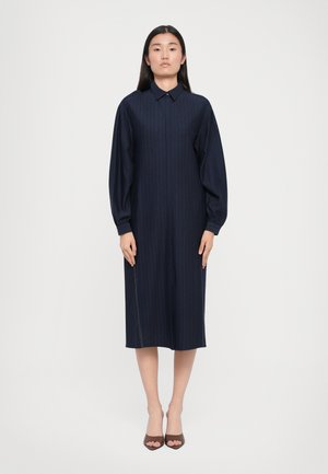 Marineblauwe midi-jurk met verticale streepjes, een klassieke kraag, pofmouwen en een rechte snit. De stof lijkt glad met een subtiele glans.