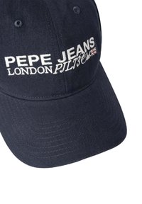 Tumši zila kokvilnas beisbola cepure ar baltu izšūtu tekstu "PEPE JEANS LONDON PILT136" priekšpusē. Izliektā viziera, teksturēta auduma.