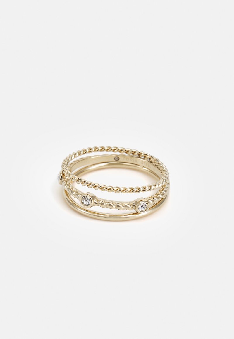 Trois délicates bagues en or, deux anneaux torsadés et un anneau lisse avec de petites pierres précieuses claires, empilés ensemble sur un fond blanc.